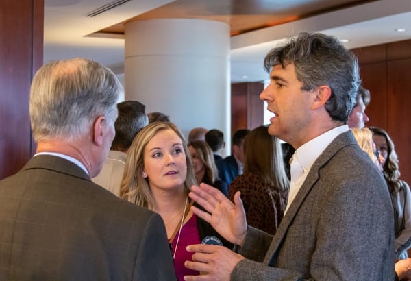a man talking to 2 others