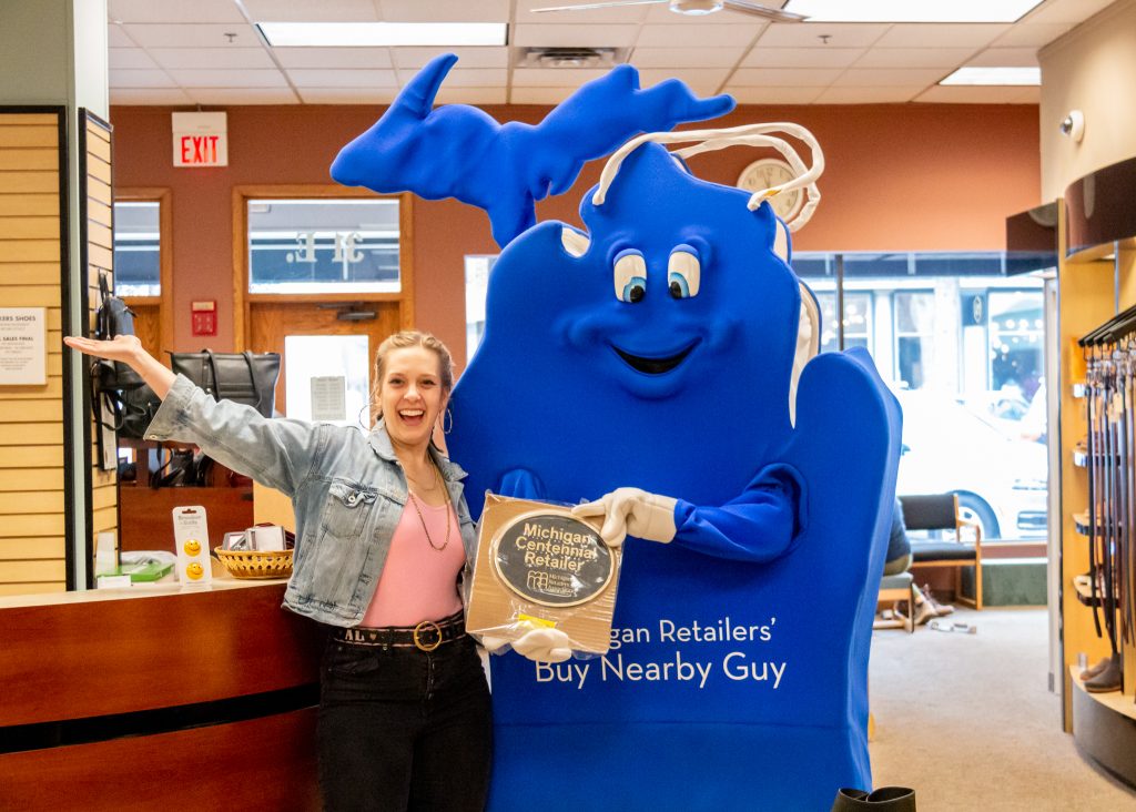 Buy Nearby Guy poses with Michigan Centennial Retailer plaque in Lokers Shoes store